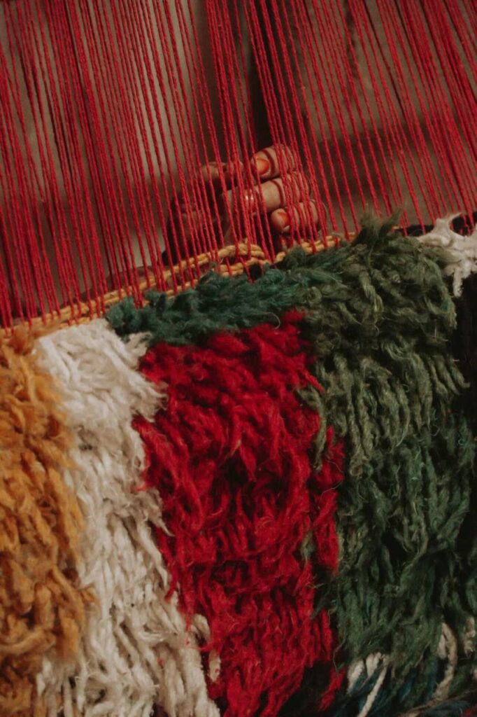 Comparison of neutral ivory Beni Ourain and vibrant multi-colored Azilal Moroccan rugs showing color palette options